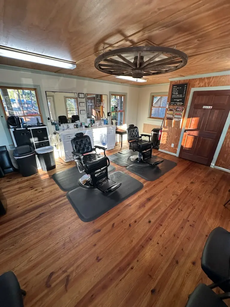 Inside Long Beach Barber — vintage chairs, wood-panel walls, wagon-wheel light